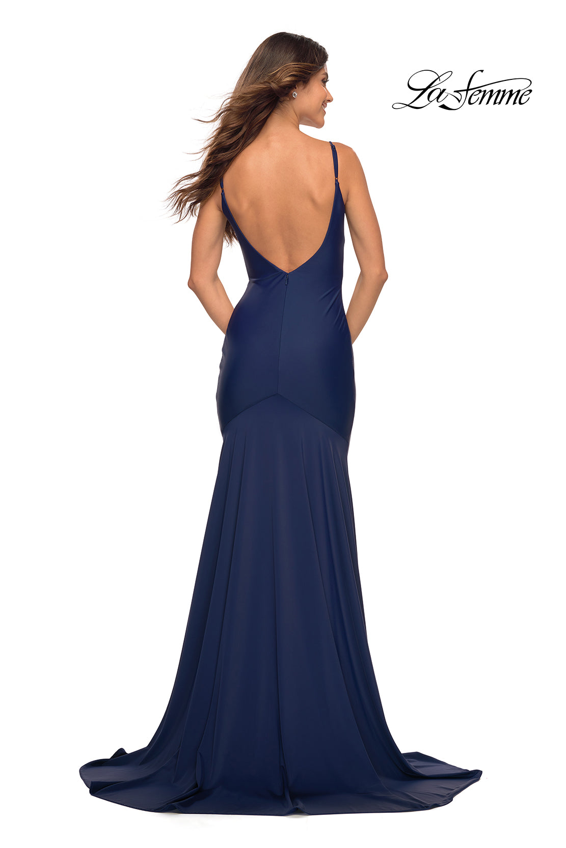 A woman models the La Femme Backless Long Prom Dress with Train in navy, featuring thin straps and a floor-length silhouette, as she stands with her back to the camera. The
